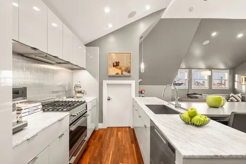 a kitchen with a sink a stove and chairs