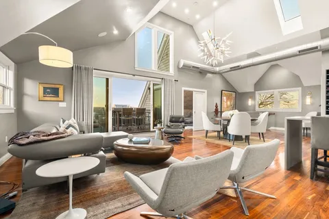 a living room with furniture a chandelier and a large window