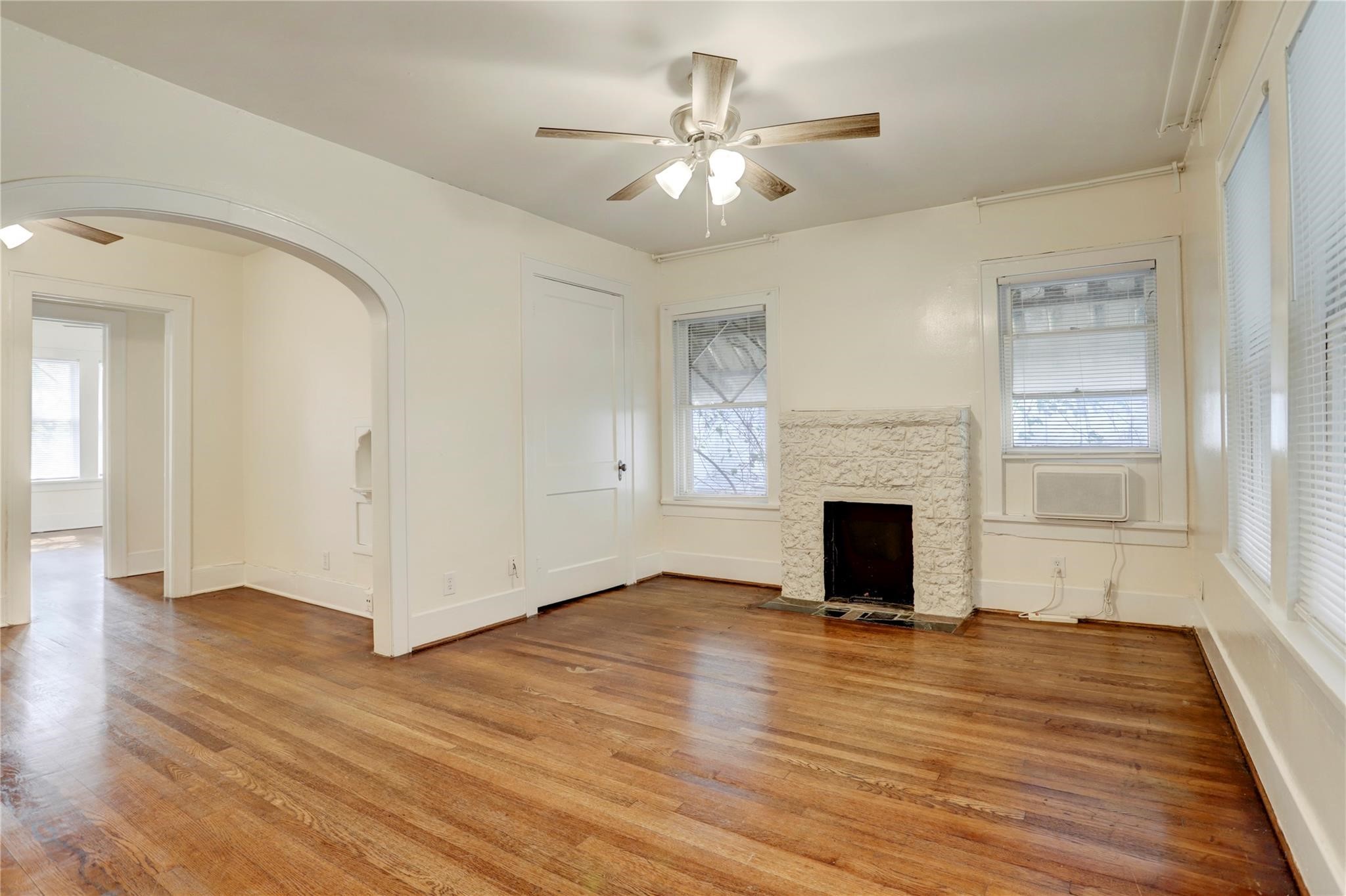 607 West Pierce Street Houston, TX 77019 - Photo 4 of 20 an empty room with wooden floor fireplace and windows