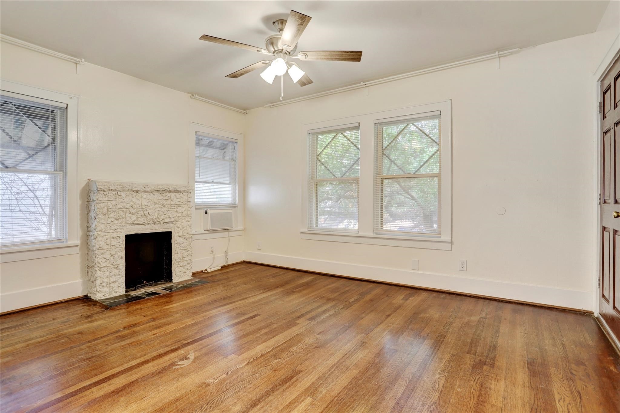 607 West Pierce Street Houston, TX 77019 - Photo 5 of 20 an empty room with windows fireplace and wooden floor