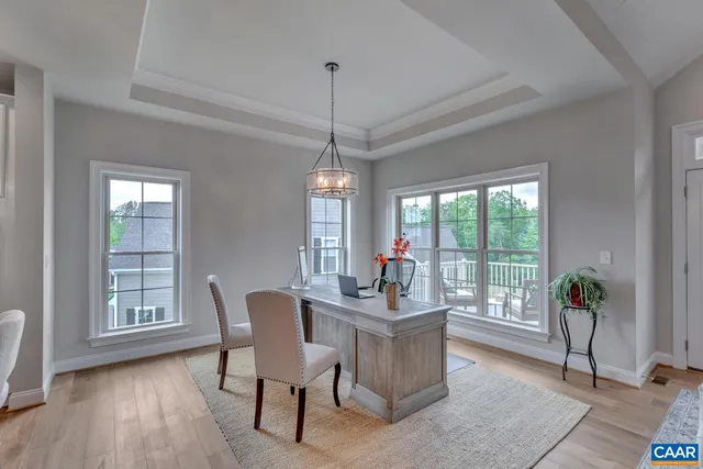a dining room with furniture a chandelier and wooden floor