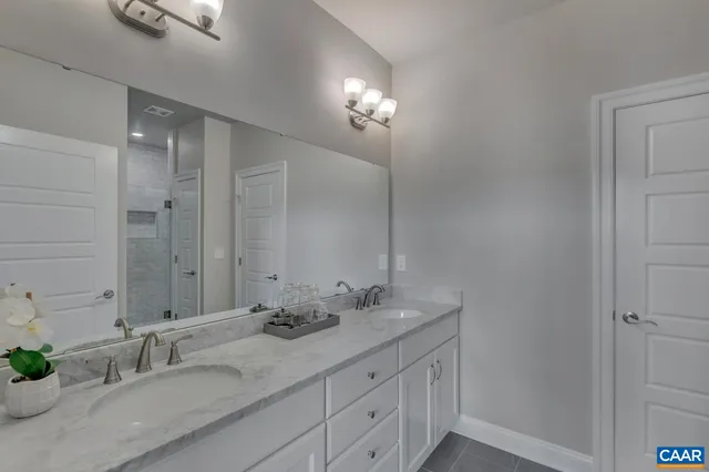 a bathroom with double vanity sink and a mirror