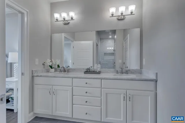 a bathroom with white cabinets and sink