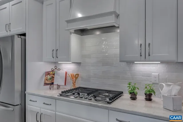 a kitchen with white cabinets and a stove