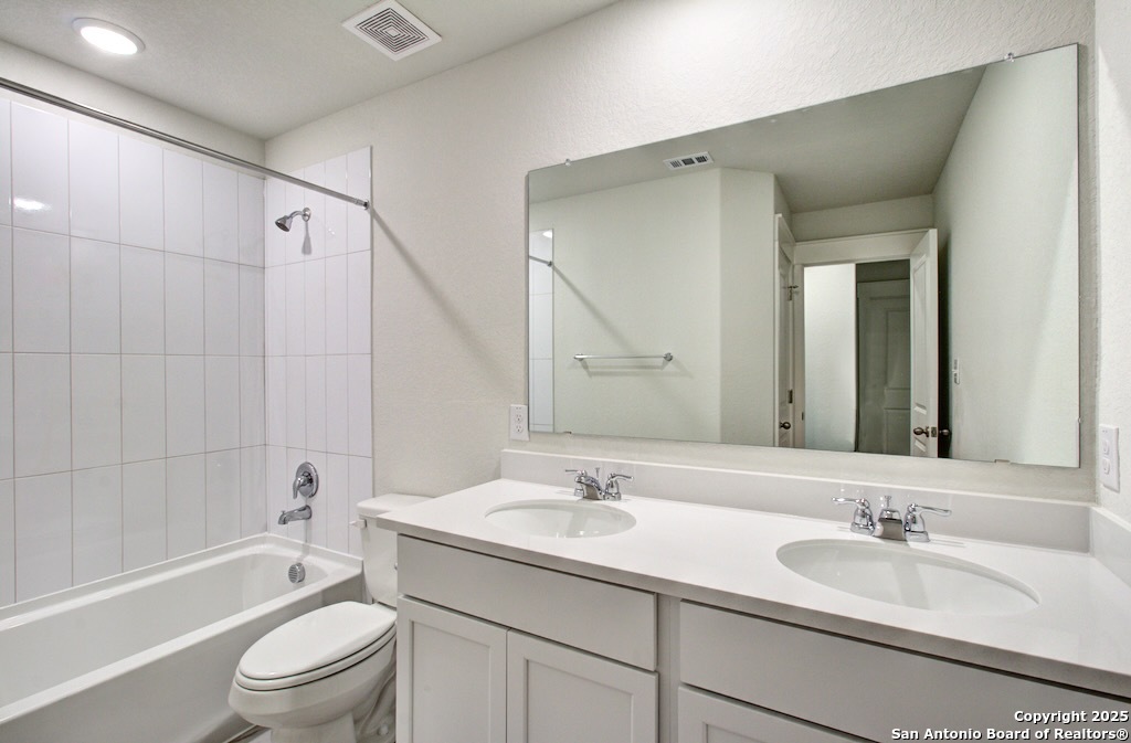 3625 Meteor Road New Braunfels, TX 78130 - Photo 30 of 39 a bathroom with a granite countertop sink a toilet and shower