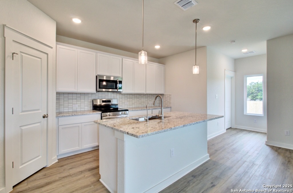 3625 Meteor Road New Braunfels, TX 78130 - Photo 4 of 39 a kitchen with a sink a microwave a stove and refrigerator