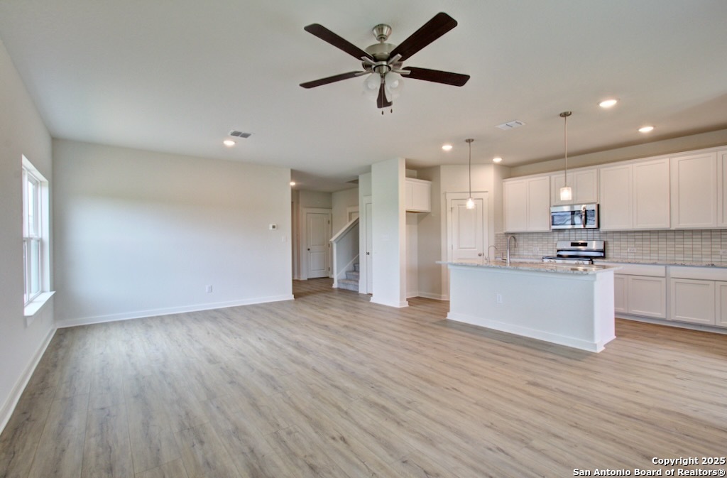 3625 Meteor Road New Braunfels, TX 78130 - Photo 6 of 39 a view of kitchen with cabinets wooden floor and a ceiling fan