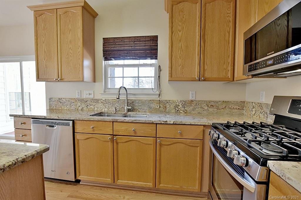 1021 Kilpatrick Lane Fort Mill, SC 29708 - Photo 14 of 34 a kitchen with granite countertop a stove top oven cabinetry a sink and a window