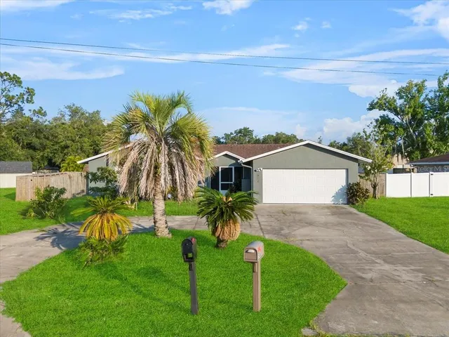 a view of a house with a yard and potted plants