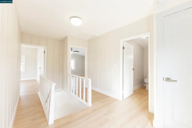a view of a hallway with white walls and entryway