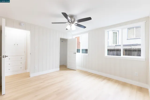 a view of an empty room with window and cabinet