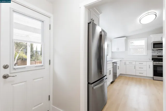 a kitchen with stainless steel appliances a refrigerator and a stove top oven