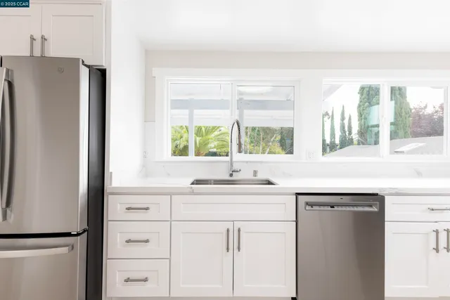 a kitchen with a sink a refrigerator a stove and a window