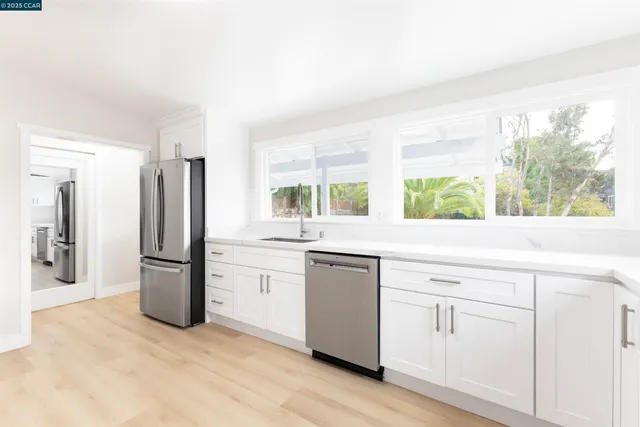 a kitchen with a refrigerator sink and large window