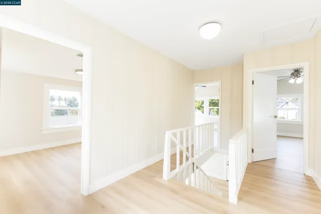 a view of a hallway with wooden floor and dining room
