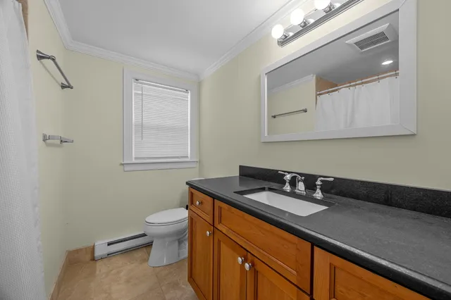 a bath room with a sink a toilet and a mirror