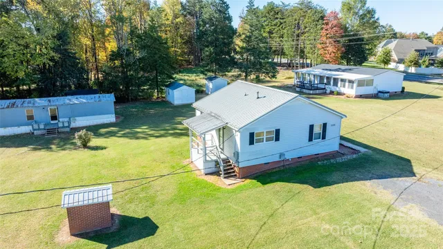 a aerial view of a house with a yard table and chairs