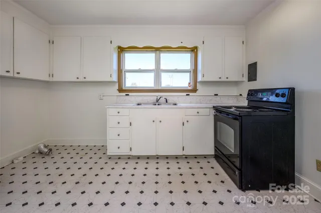 a kitchen with a sink a stove a refrigerator and cabinets