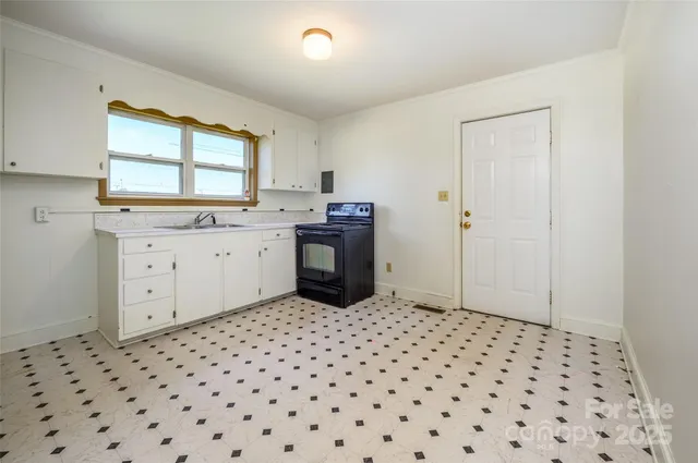 a room with a black white checkered floor with a stove top oven