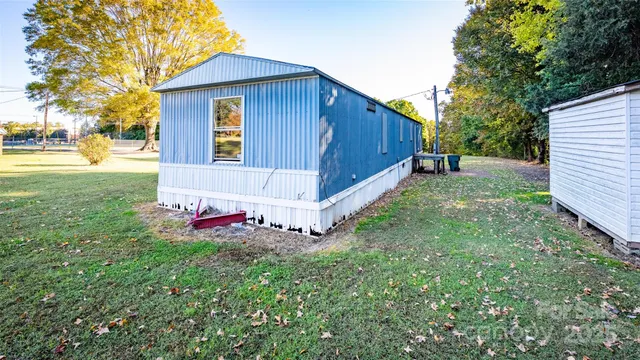 a view of backyard with wooden fence and large trees