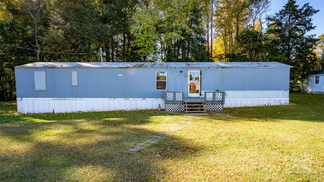 a view of a swimming pool with a chair and trees in the background