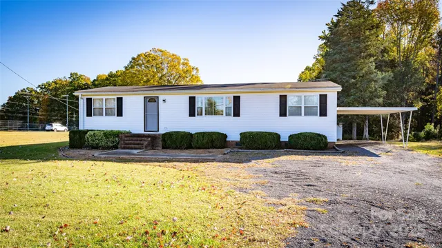 a front view of house with yard and trees around