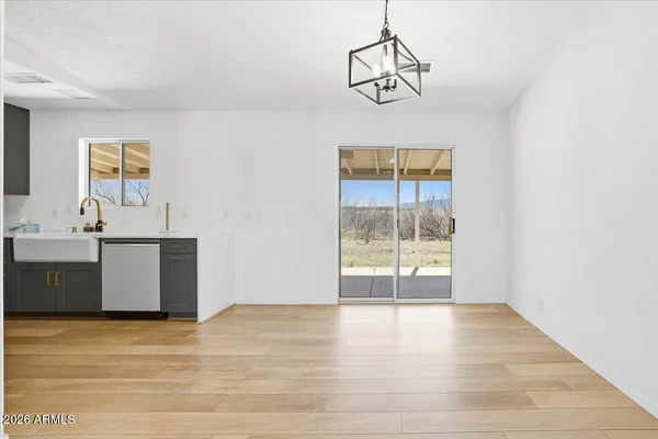 a view of a kitchen with wooden floor and a window