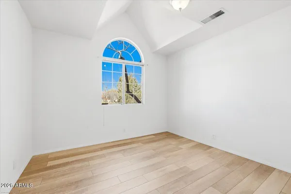 a view of a room with wooden floor and a window