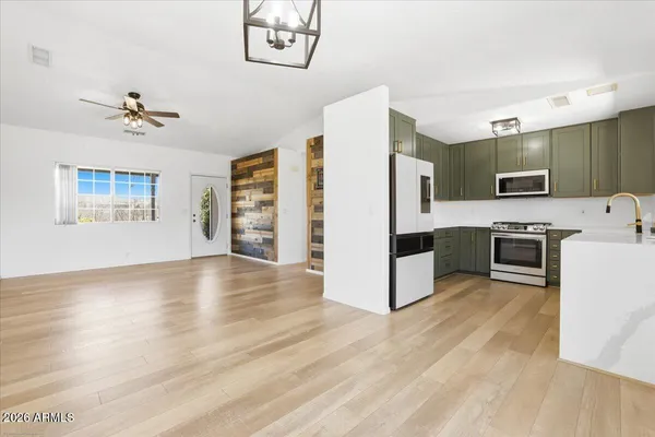 a view of kitchen with cabinets stainless steel appliances and wooden floor