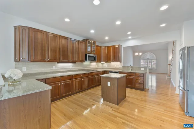 a kitchen with stainless steel appliances granite countertop a sink wooden cabinets and granite counter tops