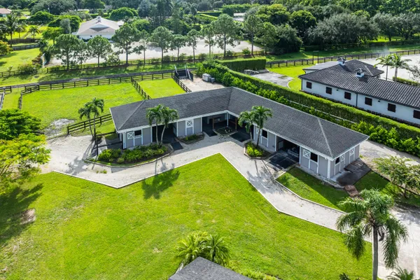 an aerial view of a house with swimming pool and garden