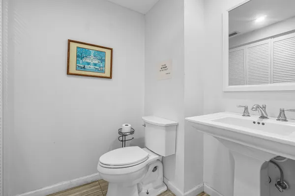 a bathroom with a sink mirror and toilet