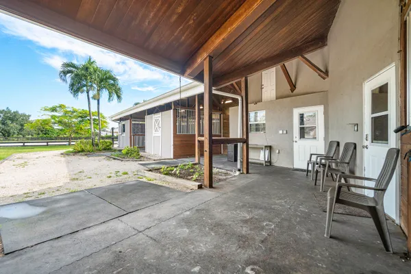 a view of a porch with furniture and a yard