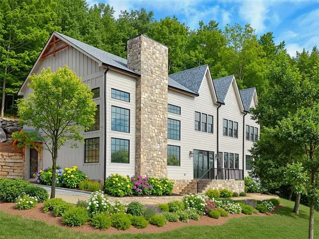 a front view of a house with a yard and potted plants