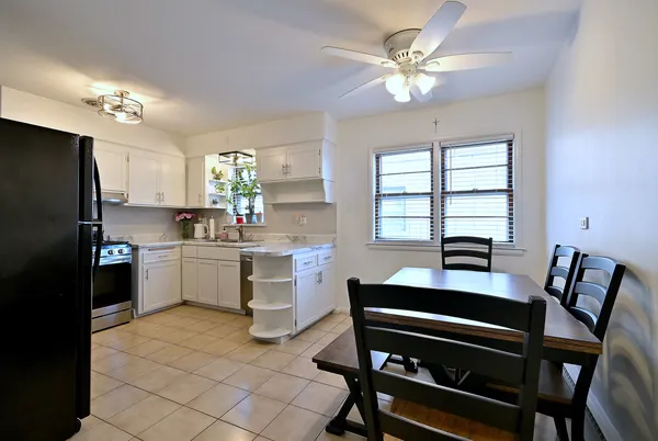 a kitchen with a dining table chairs and a refrigerator