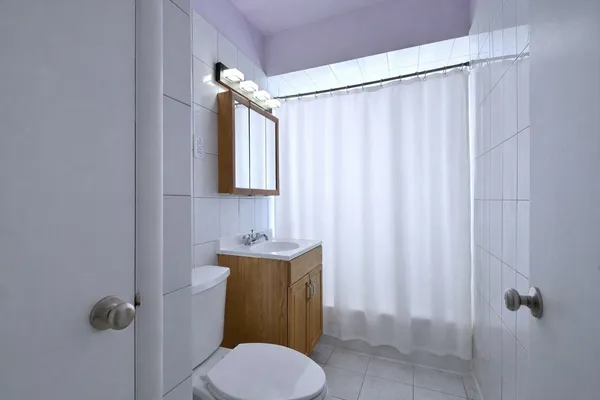 a bathroom with a toilet a sink and mirror