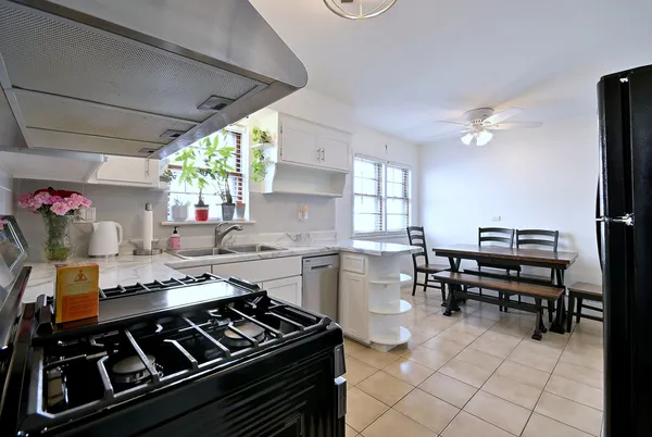 a kitchen with a stove a sink and a dining table