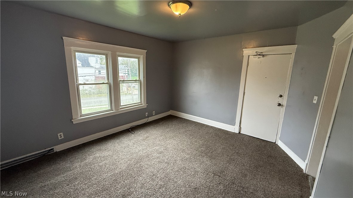 1187 Addison Road, Unit 4 Cleveland, OH 44103 - Photo 12 of 15 Carpeted interior room with neutral gray wall paint, white trim, and a prominent window assembly
