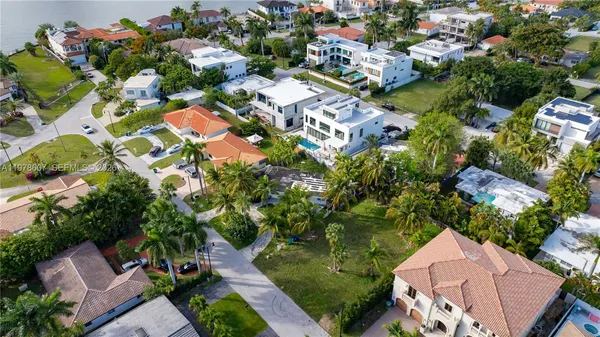 an aerial view of residential houses with outdoor space and trees all around