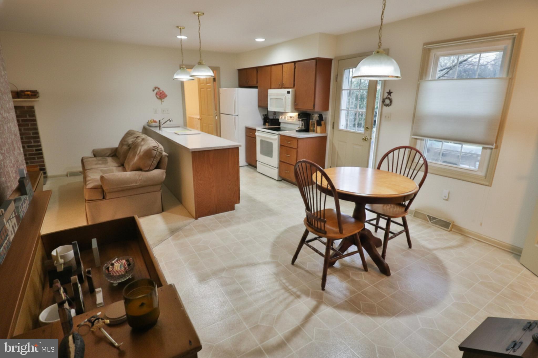 588 Crosswinds Drive Lititz, PA 17543 - Photo 6 of 38 a kitchen with stainless steel appliances kitchen island granite countertop a dining table chairs and a refrigerator
