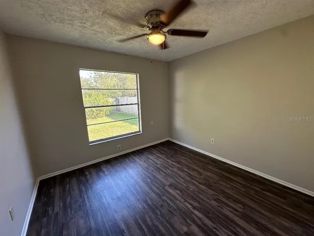 a view of room with window ceiling fan and hardwood floor