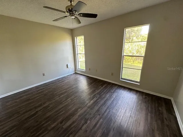 a view of a room with wooden floor and small window
