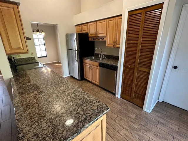 a kitchen with granite countertop a refrigerator and a stove