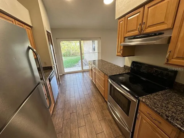 a kitchen with wooden floors and stainless steel appliances