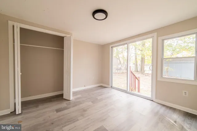 a kitchen with granite countertop a stove a refrigerator and white cabinets with wooden floor