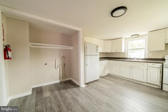 a kitchen with white cabinets and white appliances