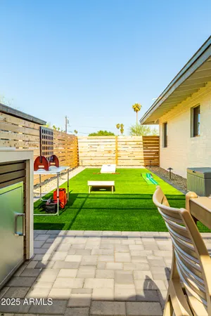 a view of a backyard with couches plants and large tree