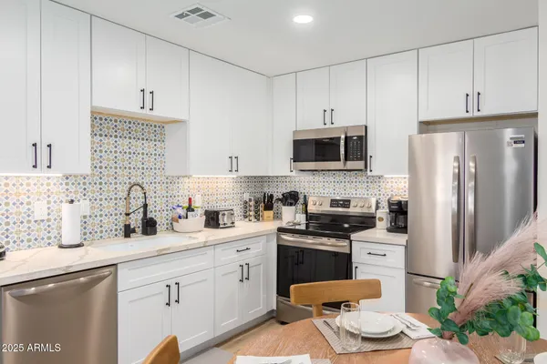 a kitchen with stainless steel appliances a stove refrigerator sink and microwave