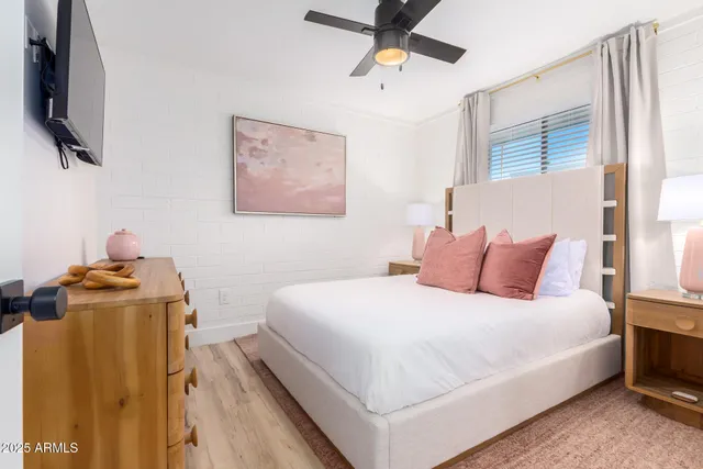 a bedroom with a bed and a flat tv screen on the dresser