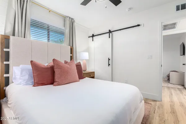 a bedroom with a bed and wooden floor